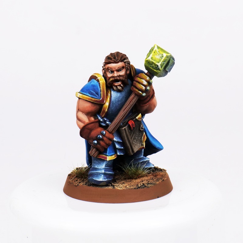 Painted human paladin miniature with holy sledge hammer and blue cloak